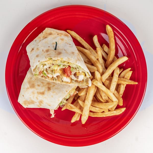 Chicken wrap with lettuce, tomato, and sauce, served with golden french fries on a red plate.